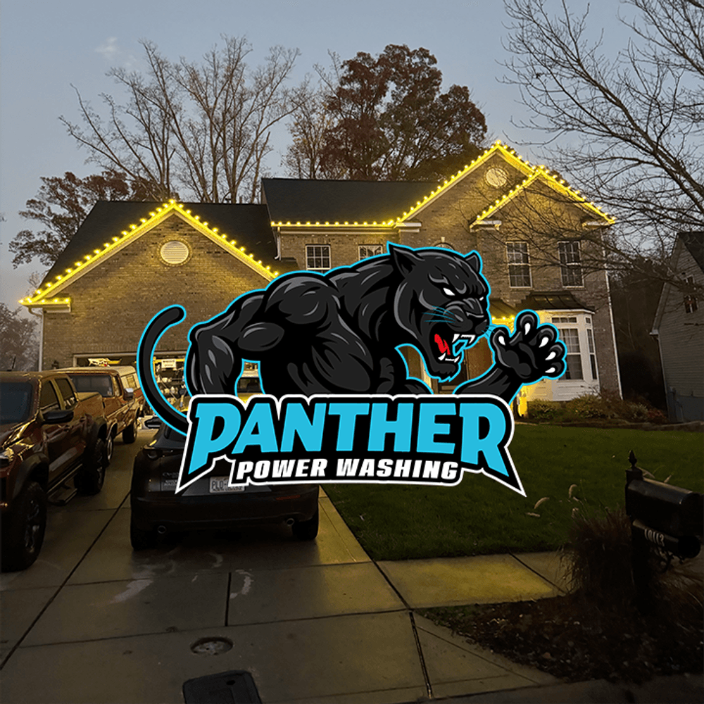 House illuminated with yellow lights, featuring Panther Power Washing logo in front.